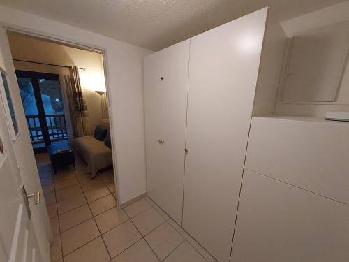 eine Küche mit einem weißen Schrank und einem Zimmer in der Unterkunft Studio Mezzanine Piscine presqu'île de Giens in Hyères