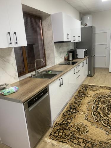 a kitchen with white cabinets and stainless steel appliances at Будинок з чаном in Druzhba