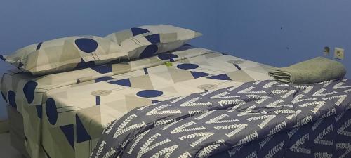 Una cama con un edredón y almohadas encima en Ponta Family holiday house, en Ponta do Ouro