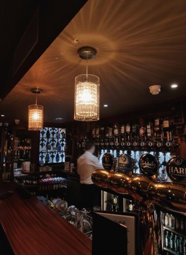 a bar with a man standing behind the bar at The Terrace Hotel in Magherafelt