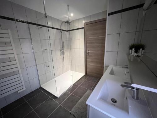 ロウファッハにあるSand & Chill - Appartement 65Rのシャワーと洗面台付きのバスルーム