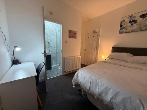 ベッドフォードにあるCosy Six Bedroom house in Bedford Townのベッドと机と窓のある寝室