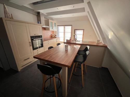 ロウファッハにあるSand & Chill - Appartement 65Rのキッチン(木製テーブル、いくつかの椅子付)
