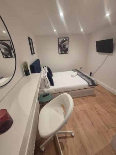 a small room with a bed and a chair at 2Bed Ground Floor Apartment With Private Garden in London