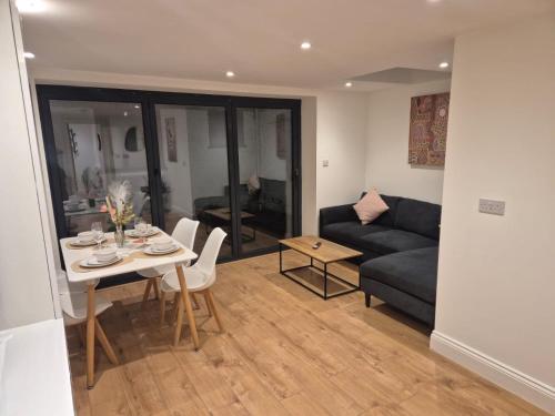 a living room with a couch and a table at 2Bed Ground Floor Apartment With Private Garden in London