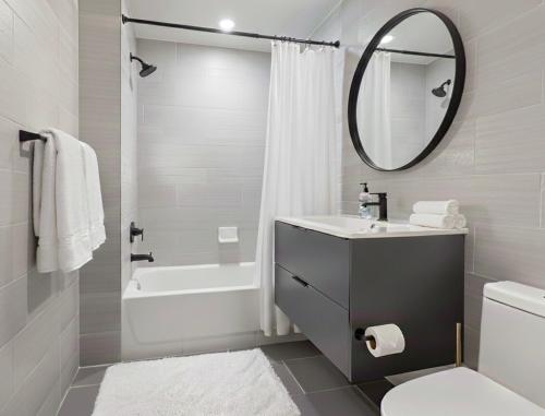 a white bathroom with a sink and a mirror at Charming Brooklyn Flat in Brooklyn