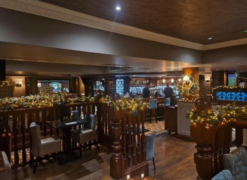 The Terrace Hotel في ماغيرافيلت: مطعم به طاولات وكراسي وبار