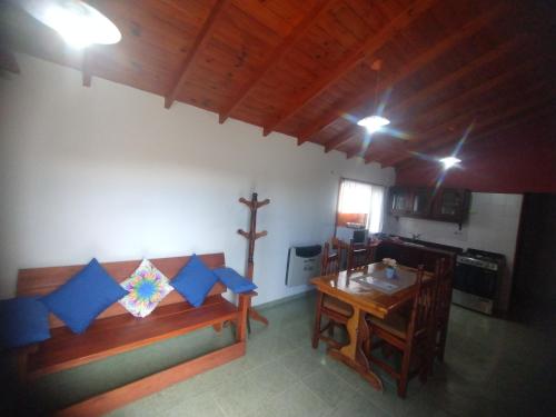 Una sala de estar con una mesa y una cruz en la pared. en cabaña refugio junto al cerro, en San Luis