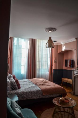 a bedroom with a bed and a window and a table at La Maison d'Augustin in Mont-de-Marsan