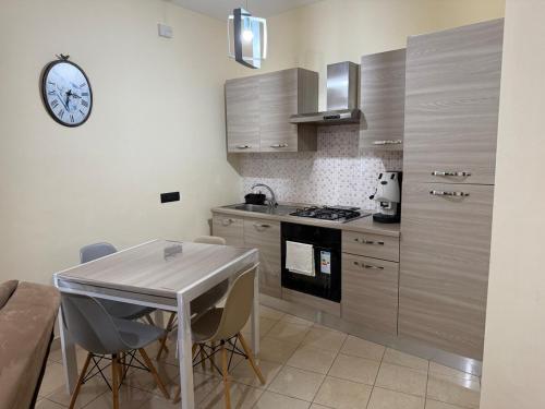 a kitchen with a table and a clock on the wall at Rama house in Caserta