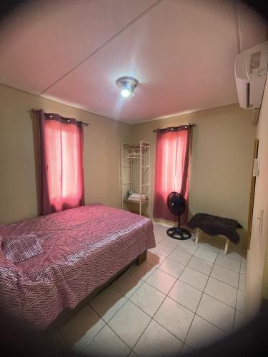 una camera da letto con un letto e due tende rosse di House on the mountain a Willemstad