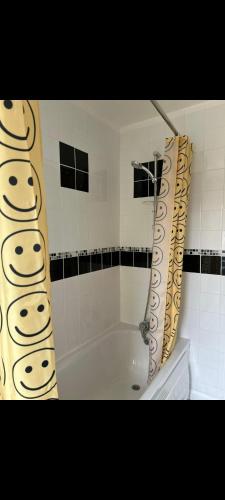 een badkamer met een badkuip en een douchegordijn bij Grove manor in Streatham Vale