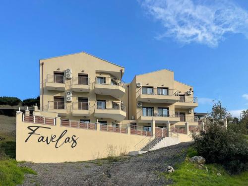 a building on a hill with the words familles at Favelas Luxury Apartments in Kavála