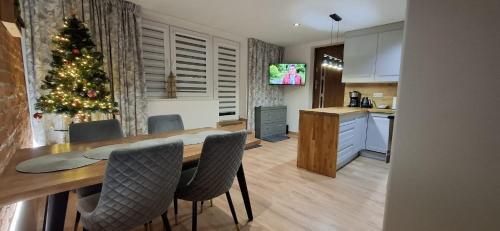 cocina con mesa de comedor y árbol de Navidad en Willa Rosa-apartamenty z prywatną sauną, en Szklarska Poręba