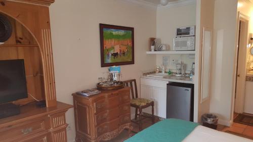 a small kitchen with a sink and a microwave at The Caribbean Court Boutique Hotel in Vero Beach