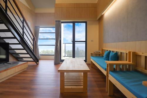 Habitación con 2 camas, mesa y escalera. en 光隅民宿 Light Haus Inn, en Hengchun