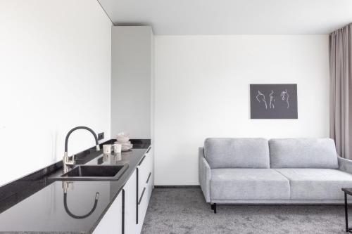 een keuken met een wastafel en een bank in een kamer bij Varenastay in Varėna