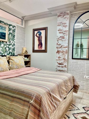 a bedroom with a bed and a painting on the wall at Beachfront Private Apartment in Pueblo Torviscas Sunset Harbour in Adeje