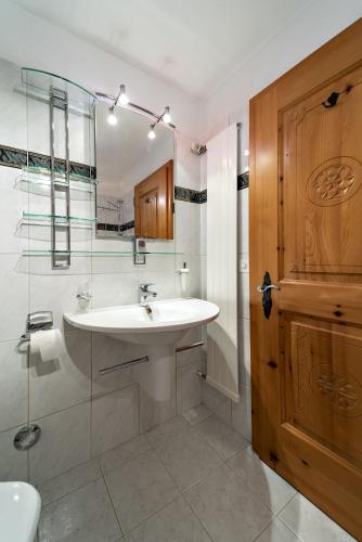 a bathroom with a sink and a glass shower at Apartments Chesa Guardaval in Surlej
