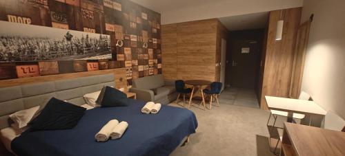 a bedroom with a blue bed with towels on it at Apartament Czarna Góra Blue in Sienna