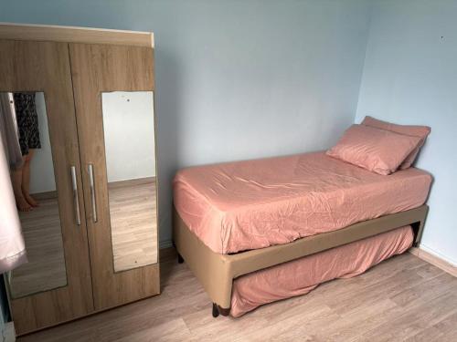a small bedroom with a bed and a mirror at Badaró's Beach in Praia Grande