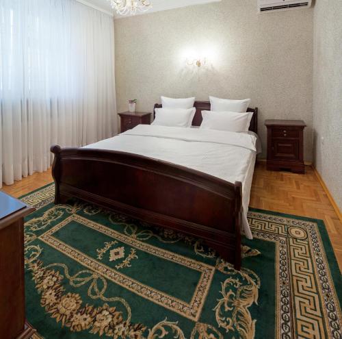 a bedroom with a large bed with a green rug at Villa Romantica on Vlaicu-Pircalab in Chişinău