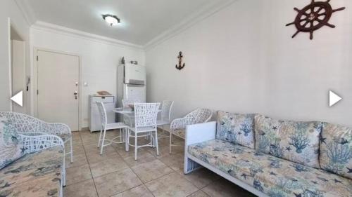 グアルジャにあるPraia de Pitangueirasのソファとテーブルと椅子のあるリビングルーム