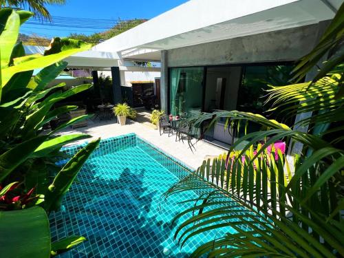 een zwembad naast een huis met planten bij Intimate Oasis, 2 bedrooms Pool in Kata Beach