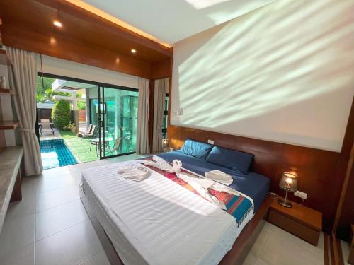 een slaapkamer met een groot bed en een balkon bij Intimate Oasis, 2 bedrooms Pool in Kata Beach