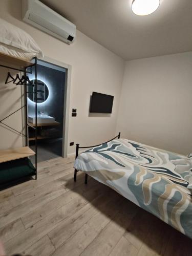 a bedroom with a bed and a flat screen tv at La Morra Apartments in La Morra