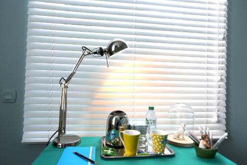 a desk with a lamp and a table with cups at Queen Christine in Villeneuve d'Ascq