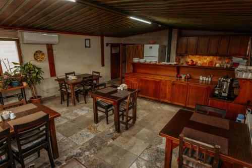a restaurant with wooden tables and chairs and a kitchen at Hanzade Cappadocia in Goreme