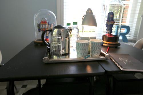 a tray with a tea kettle and cups on a table at Queen Christine in Villeneuve d'Ascq