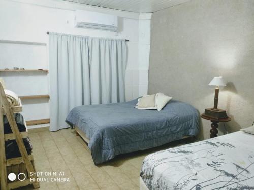 una camera d'albergo con due letti e una finestra di Departamento Monte Caseros a Monte Caseros