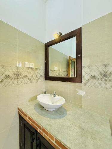 a bathroom with a sink and a mirror at Aura Villa in Polonnaruwa