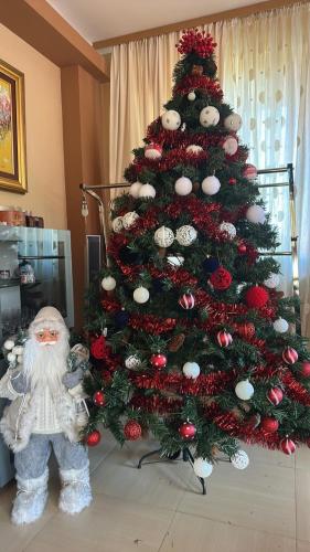 a christmas tree with a santa clause next to it at Ava Apartment Pamporovo in Pamporovo