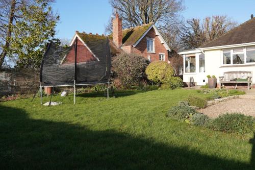 una casa con techo negro en un patio en Big Group Bungalow, Sleeps 9, Perfect for Families, en Sturminster Newton