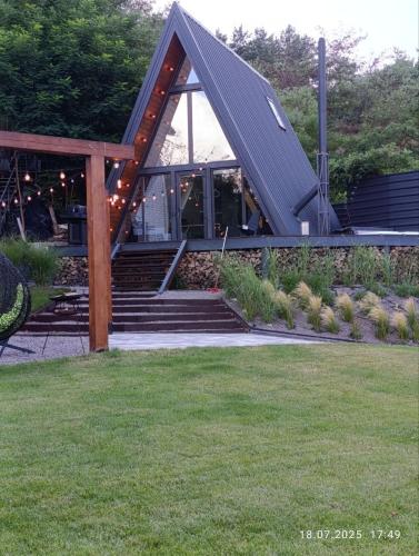 A-frame будинок в м Черкаси з видом на Дніпро та виходом в Лісопаркову зону في تشيركاسي: منزل بسقف معدني وبعض السلالم