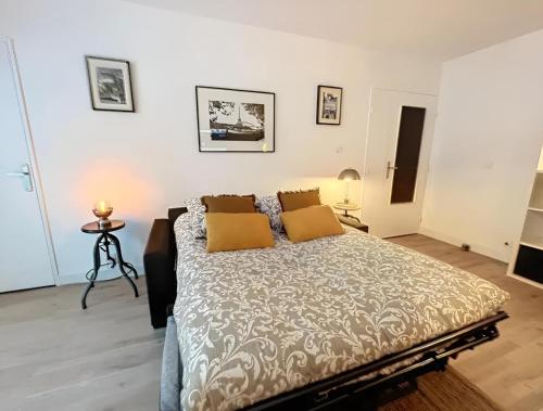 a bedroom with a large bed with two yellow pillows at Appartement centre Orsay in Orsay