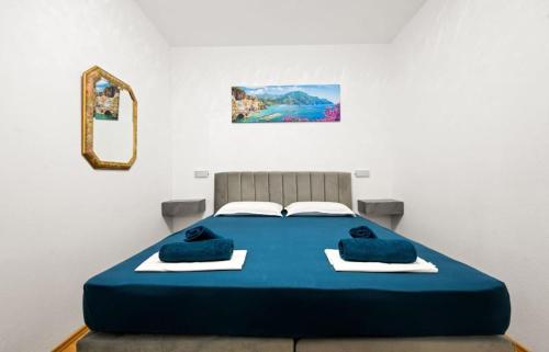 ein blaues Bett in einem Zimmer mit einem Spiegel in der Unterkunft Vila Zagora in Drniš