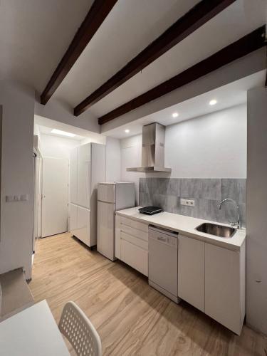 a kitchen with white appliances and a wooden floor at Restored house near Valencia in Simat de Valldigna