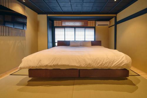 una camera da letto con un letto grande con una finestra di 御宿 凪ぐ Takayama a Wada