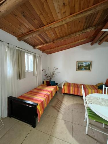 a bedroom with two beds and a wooden ceiling at Cabaña brisas del lago in Villa Parque Siquiman