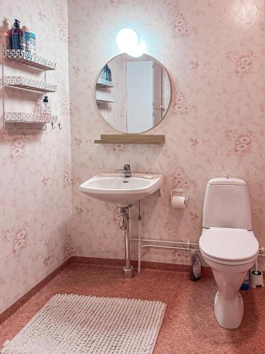 a bathroom with a sink and a toilet and a mirror at Aurora House in Karungi