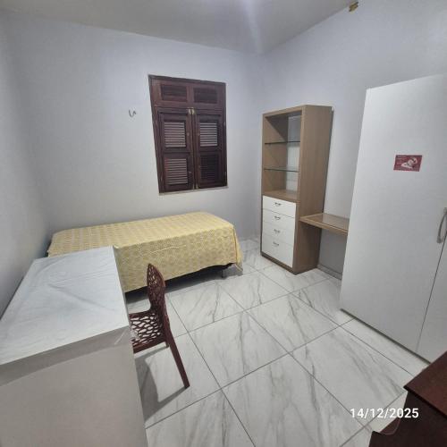 Casa de condomínio privativo في فورتاليزا: غرفة صغيرة بها سرير وطاولة وكرسي