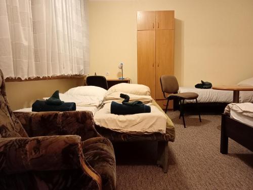 een ziekenhuiskamer met 3 bedden en een bank bij Hotel Sowa in Częstochowa