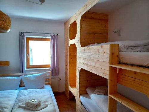 Alpen Lodge in Osterhofen - Berge, Ruhe & Natur في بايريشزيل: غرفة نوم بها سريرين بطابقين ونافذة