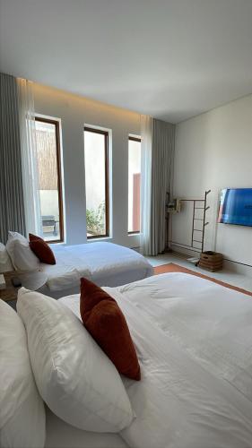 Ash Shuqayqبريز الشقيق的一间带三张床和两扇窗户的卧室