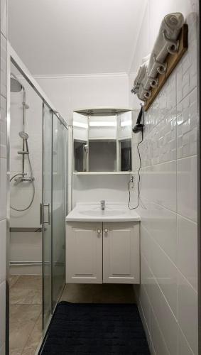 a white bathroom with a shower and a sink at Famenne Escape in Marche-en-Famenne