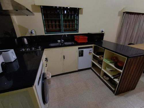 Una cocina con encimera negra y fregadero. en LG Palms, en Sigatoka